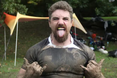 A mud-covered Lions player grinning after a match